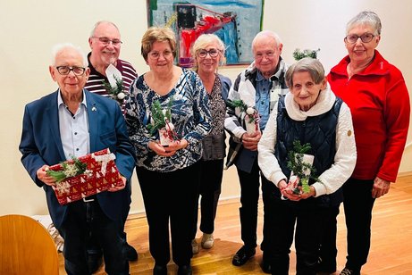 Sieben Personen stehen mit Pr&auml;senten in den H&auml;nden, f&uuml;r ein Gruppenbild zusammen