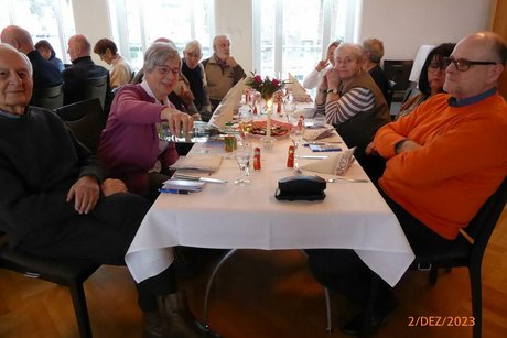 Eine Gruppe Menschen sitzt gemeinsam an einem Tisch.