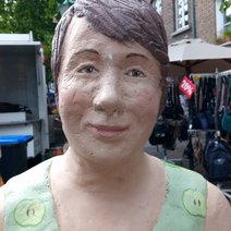 Die Skulptur Alltagsmensch in Straelen ist eine Frau mit braunem Haar und grünem Sommerkleid.