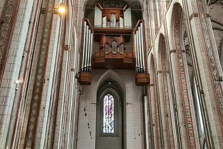 Blick auf die Orgelempore in einem Kirchenschiff.
