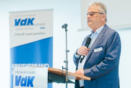 Ein Mann spricht in ein Mikrophone.