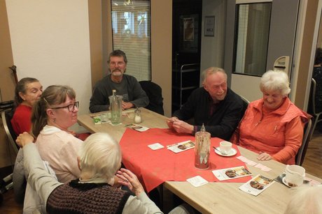 Mehrere Personen sitzen an einem langen Tisch.