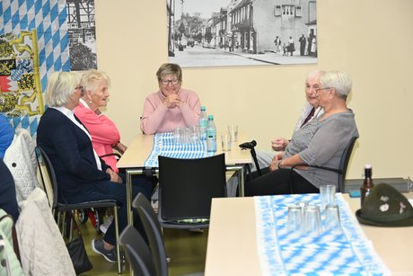 Mitglieder sitzen an einem Tisch bei einer Unterhaltung
