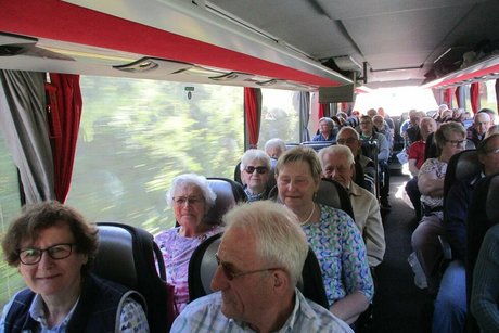 Eine Gruppe Menschen sitzt gemeinsam im Reisebus.