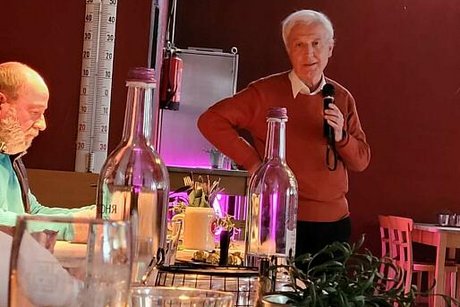 Dieter Weinbrenner steht mit Mikrofon in der Hand und berichtet von der Kassenprüfung.