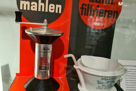 Eine alte Teemühle und ein Teefilter aus Porzellan von Melitta sind als Ausstellungsstück im Museum zu sehen.