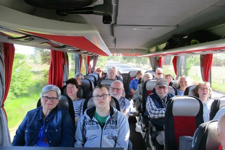 Eine Gruppe Menschen sitzt gemeinsam im Reisebus.