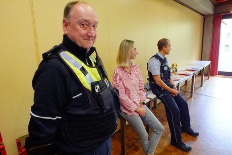 Drei Personen von der Polizei halten einen Vortrag.