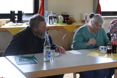 2 Personen sitzen an einem Tisch und h&ouml;ren dem Vortrag zu.