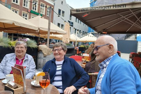 Drei Personen sitzen im Au&szlig;enbereich eines Caf&eacute;s in Venlo.