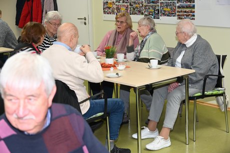 Mitglieder sitzen an einem Tisch und unterhalten sich