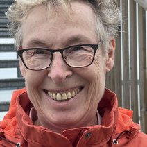 Das Bild zeigt Barbara in einer orangefarbigen Outdoorjacke im Portraitformatai