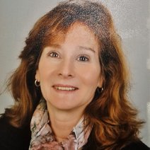 Frau mittleren Alters mit Lächeln und langen rötlichen Haaren