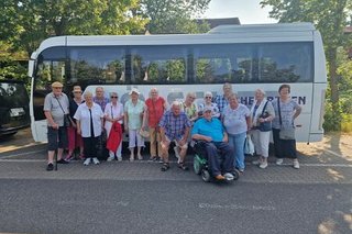 Ausflugsgruppe vor dem Bus