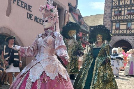 Prächtige venezianische Karnevalsköstüme vor historischer Kulisse in Riquewihr.
