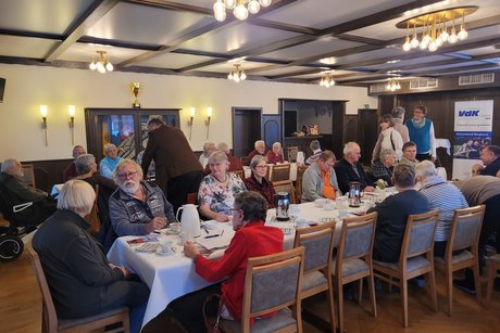 Info Nachmittag Zahlreiche Mitglieder sitzen an den Tischen bei Kaffee, Kuchen und Schnittchen.