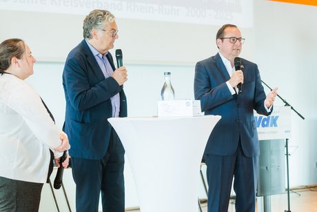 Ein Moderator unterhält sich mit einem Mann und einer Frau.
