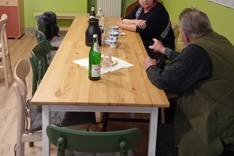 Gäste unterhalten sich. Eine Frau und ein Mann unterhalten sich am Tisch.