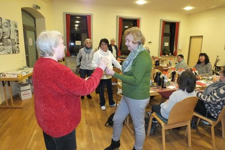 Jahresabschlusstreffen der Frauenvertreterinnen. Eine Frau übergibt ein Präsent an eine andere Frau als Dank schön von der Gruppe.
