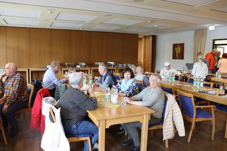 Jahreshauptversammlung 2026 Mehrere Personen sitzen an langen Tischen und unterhalten sich.