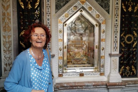 Eine Frau steht neben einem Bild in der Kirche.