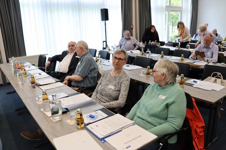 Delegierte sitzen an langen Tischen
