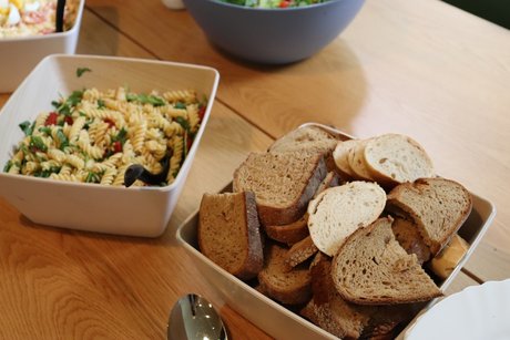 Das Buffet ist eröffnet. Ein Schüssel mit frischem Brot und eine Schüssel mit Nudelsalat.
