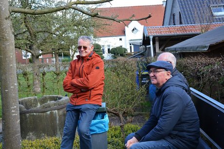 Männer sitzen auf der Terrasse und hören zu