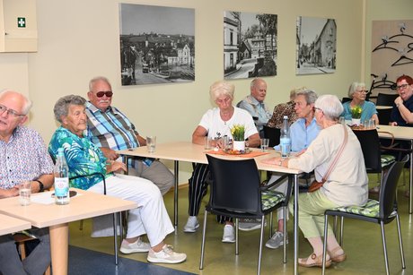 Menschen sitzen am Tisch bei einer Unterhaltung
