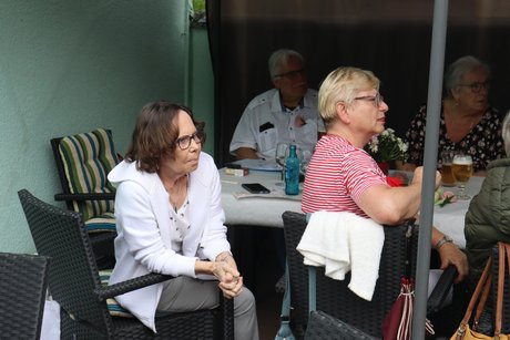 Grillnachmittag vom VdK Ortsverband Borbeck gemeinsam mit dem Ortsverband Altendorf. Zwei Frauen hören einer Sprecherin zu.