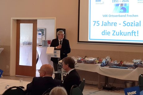 Der KV-Vorsitzende Christian Kellermann spricht vor einer Leinwand &uuml;ber die Vergangenheit und Zukunft der Arbeit im VdK