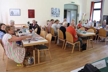 Treffen der Vertreterinnen der Frauen. Mehrere Frauen sitzen an langen Tischen und verfolgen den Vortrag.