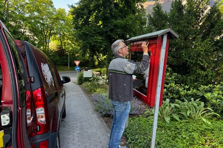 Das Bild zeigt Rolf Römhild bei seinem Einsatz für den VdK vor dem Schaukasten.