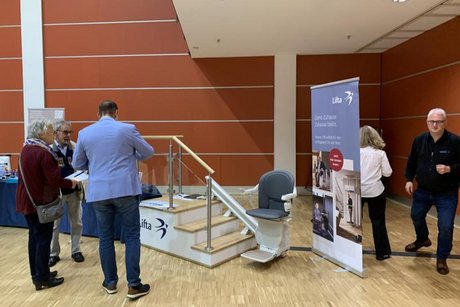 Das Bild zeigt Intresserte an einem Messestand für Treppenlifthilfen