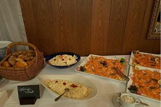 Brotkorb, Schüsseln mit Salaten und Platten mit Räucherlachs auf einem Tisch