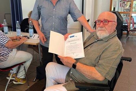Klaus Eichst&auml;dt &uuml;berreicht die Ehrennadel und Ehrenurkunde des VdK Landesverbandes