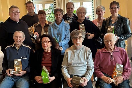 Personen stehen oder sitzen f&uuml;r Gruppenfoto