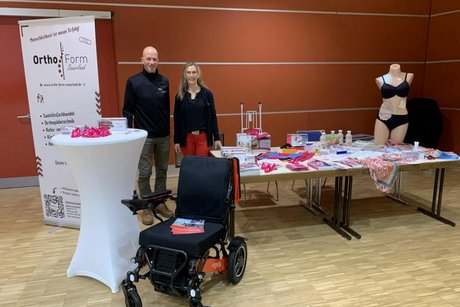 Das Bild zeigt zwei Mitarbeiter für einen Sanitätsfachhandel und Orthopädietechnik vor Ausstellungsstücken