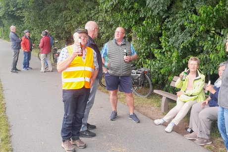 Fahrradfahrer trinken im Stehen oder sitzen ein Bierchen