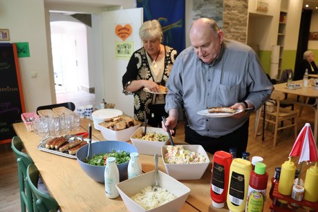 Mitglieder bedienen sich am Buffet. Zwei Personen bedienen sich am Buffet.