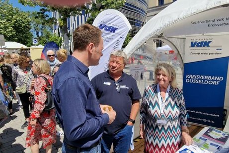 Drei Menschen stehen im Gespräch am Informationsstand des VdK Düsseldorf