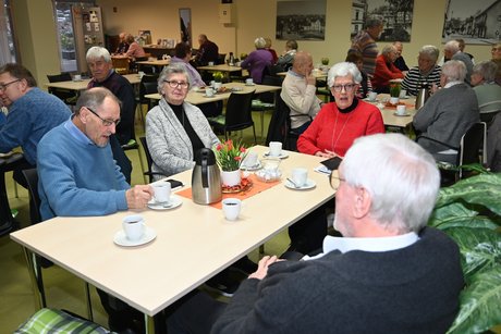 Mitglieder sitzen an einem Tisch und unterhalten sich