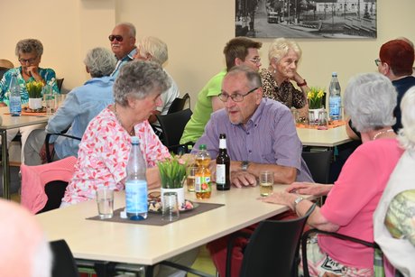 Menschen sitzen am Tisch bei einer Unterhaltung