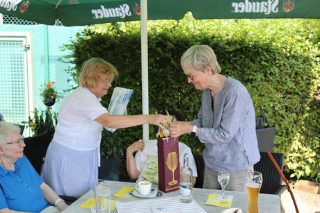Eine Frau erhält eine Urkunde und ein Präsent.