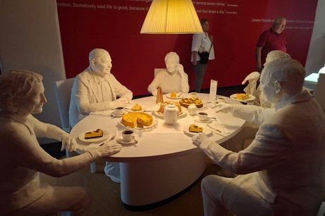 Hier sitzen Puppen bei einer Kaffeetafel.
