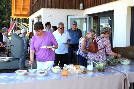 Mitglieder am Grillbuffet Mitglieder stehen am Grillbuffet