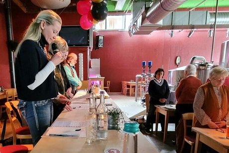 Cathrin Bergatt-Huis steht mit Mikrofon am Vorstandstisch