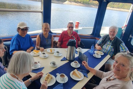 Mehrere Mitglieder beim Kaffee und Kuchen auf dem Boot