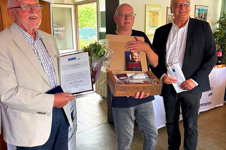 Jubilars- und Ehrenamts-Verleihung des VdK-Ortsverbandes Essen - Katernberg - Stoppenberg - Schonnebeck. Drei Männer stehen nebeneinander mit Urkunde, Silbermedaille und Präsent in den Händen.