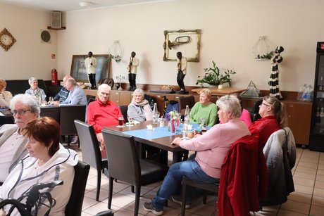 Frühlingsfest Mehrere Menschen sitzen an Tischen und unterhalten sich miteinander.